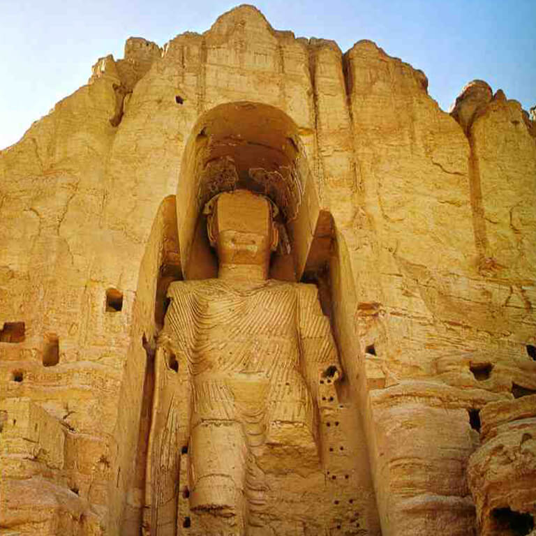 A stone Buddha carved into a rock wall.