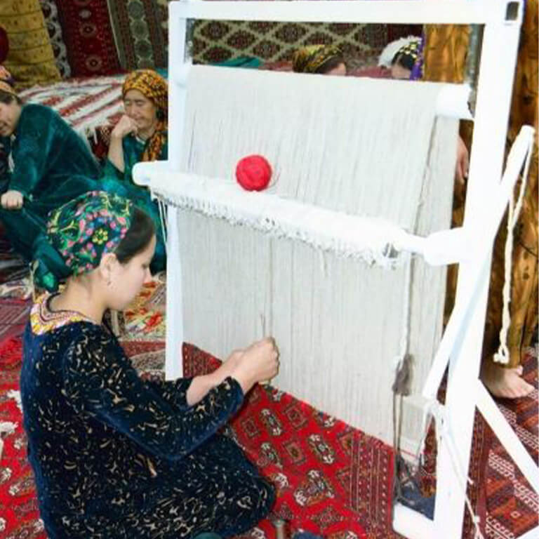 A woman making a rug.